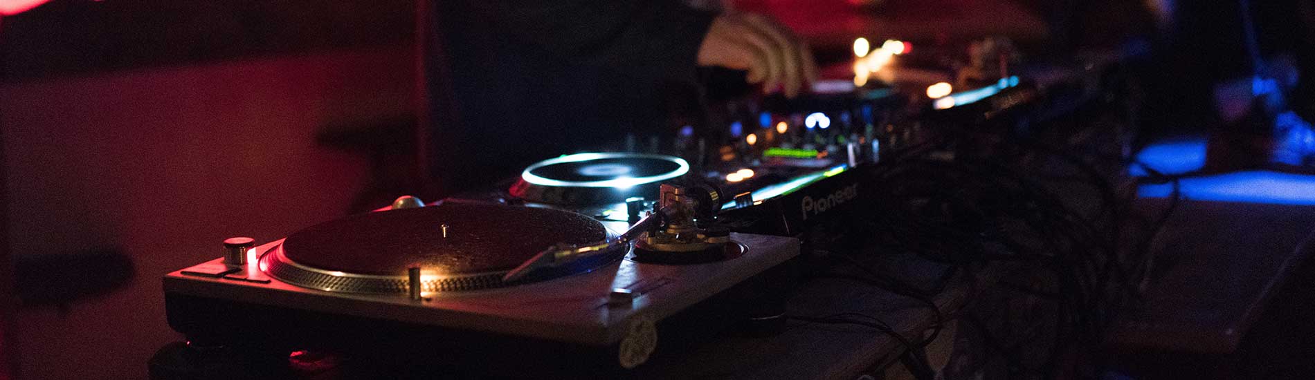 DJ-Pult und DJ bei der Musikdarbietung.